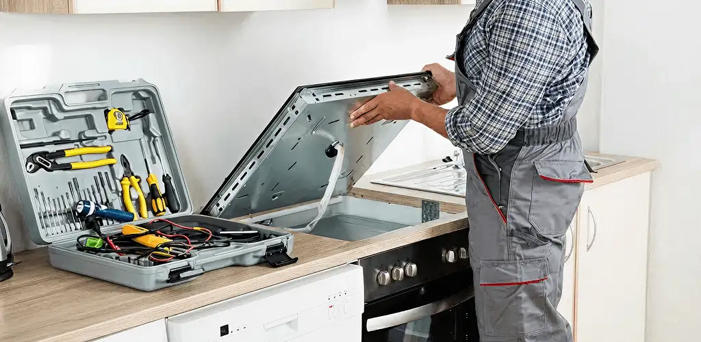 Handyman repairing a cooktop and checking wiring connections in Madison, WI