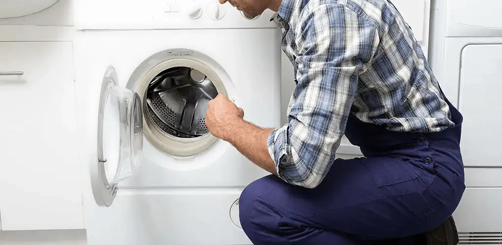 Handyman inspecting a dryer drum and internal parts for repair in Madison, WI