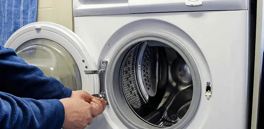 Washing machine repair handyman checking a front-load washer door and latch in Madison, WI