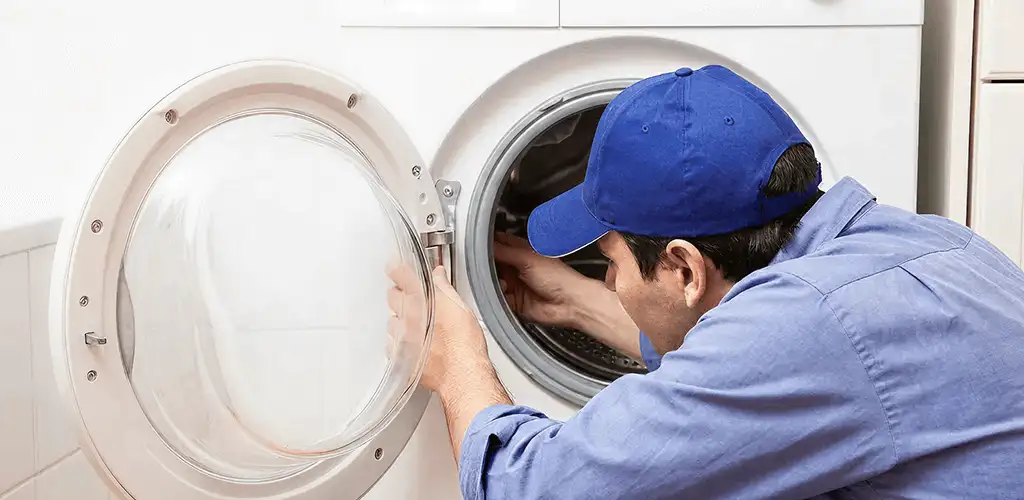 Washing machine repair handyman inspecting a front-load washer drum in Madison, WI